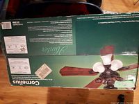 Box top showing 'Cornelius' model fan with light fixture and blades, text describing features