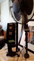 Photo showing Noma coil heater and black standing fan side by side.