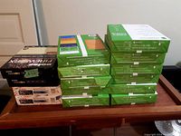 Stack of 15 reams of various printer paper brands including Grand & Toy, Xerox, and Boise Fireworx