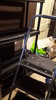 Photo showing side view of 4 shelf plastic storage unit with black plastic slatted shelves.