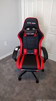 Front view of black and red GTRACING gaming chair showing seat, armrests, and overall condition.