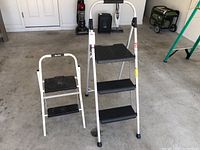 Front view showing the 4-foot Werner aluminum step ladder and 2-foot Easy Reach step stool side by side in garage setting