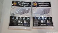 Two packs of four zippered waterproof pillow protectors in white packaging, sealed and labeled with features such as waterproof, breathable, with strong zipper.
