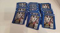 Multiple packs of unopened 2021-22 NBA sticker and card packs laid out on a flat surface, showing quantity and new condition.