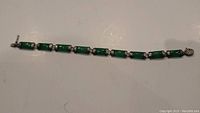 Full length view of the sterling silver and jade bracelet showing all linked segments and clasp.