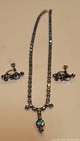 Full view of the necklace and screw-back earrings showing overall design and condition.