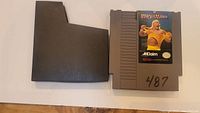 NES WrestleMania game cartridge with original black plastic sleeve for protection and storage.