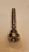Front view of a sterling silver mouthpiece showing the full length and rounded mouth cup.