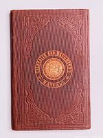 Front cover of the 1871 Manual of Mechanics in brown textured hardback with embossed scrollwork and central gold emblem saying 'Galbraith and Haughton Manuals'.