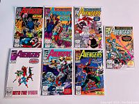 Seven Avengers comic books arranged in two rows, showing cover art and titles, displayed in protective sleeves against a white background.