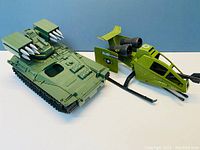 Front angle view of green tracked missile launcher and green helicopter with missiles and rotors visible