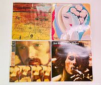 Four vintage vinyl album covers including Alice Cooper School's Out, Derek and the Dominos, Van Morrison Moondance and Bob Marley Catch A Fire viewed from above.