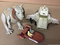Top-down view of entire vintage Star Wars toy lot showing Taun Taun figure, Mini-rig vehicle, gun accessory, and Landspeeder vehicle with figures.