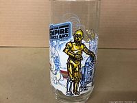 Front view of glass showing C-3PO and R2-D2 with The Empire Strikes Back logo in vibrant color.