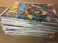 Stack of comics showing X-Men on top in bags and boards.