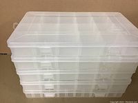 Stack of 5 closed Plano storage containers showing uniform translucent plastic construction and snap latches.
