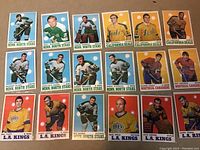 Top-down view showing all 18 hockey cards arranged in rows, featuring players from Minnesota North Stars, California Seals, Montreal Canadiens, and L.A. Kings.