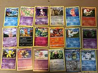 Top view of 18 rare Pokémon cards arranged in three rows, showing artwork, energy types, and rarity symbols. Cards feature holographic foil, star rarity symbol, and varied Pokémon characters from multiple sets.