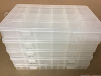Stacked view of five translucent white Plano storage containers showing plastic latches and hinged lids.