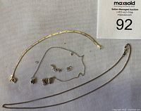 Overview photo showing all jewelry pieces: gold-tone bracelet, butterfly necklace with broken chain, and four small stud earrings