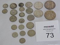 Overview of 24 silver Canadian coins on white background with lot card