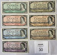 Fronts of all seven banknotes arranged on white background