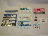 Front side view of 2010 Olympics limited edition souvenir pack including collectible stamps, three souvenir cards, two coins, two pins and a round keychain/pin in packaging.
