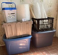 Overall setup of plastic tubs stacked with bubble wrap rolls in and around them