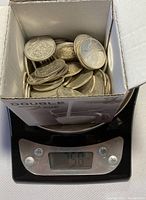 Box of coins on kitchen scale showing 758 g