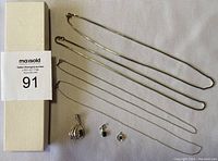 Top view showing all four sterling silver chains and three pendants with stones laid out on a light fabric background, with auction lot tag visible.