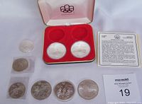 Overview of partial boxed set, loose coins and information card on table