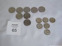 Collection of 14 U.S. dollar and half dollar coins displayed on white background with auction number card, showing worn surfaces.