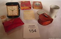 Full display of four vintage travel-related items including playing cards, travel clock, sewing kit, and collapsible cup with case on a white surface.
