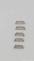 Seven elongated fancy cut smokey quartz gemstones in a line on a white background, showing size and shape clearly.