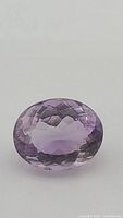 Front-facing close-up of the faceted oval amethyst showing pink-purple color and clarity.