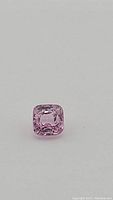 Close-up photo of the natural bubble gum pink spinel showing cushion cut and clarity.
