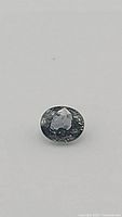 Close up front view of the untreated oval cut blue-green sapphire showing natural inclusions consistent with VS clarity.