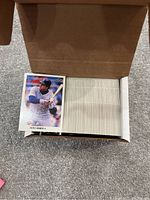 Box containing a large quantity of 1990 Leaf baseball cards, with one card of Kent Hrbek visible on top.