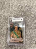 Photo of a 1993 The Royal Family trading card numbered 35 titled 'A Girl Can't Have Enough' featuring a royal female with crown and green sash, graded by BGS as 9, encapsulated in protective case.