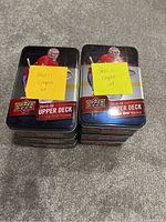 Stacks of metal tins with hockey player artwork on front, labeled with sticky notes for Series 1 and Series 2 Complete Sets