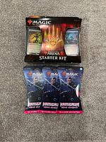 Photo of the Magic: The Gathering Arena Starter Kit sealed box and three sealed Kamigawa: Neon Dynasty booster packs on carpeted floor