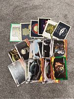 Array of various Star Wars trading cards on a carpeted surface including characters Baby Yoda (Grogu), Yoda, Darth Vader
