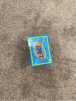 Top view of a stack of Webkinz cards showing the blue backs with logo, held by a rubber band