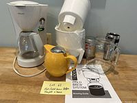 Photo of cold brew system, Philips drip coffee maker, Michael Graves yellow teapot, assorted cups, and brewing guide
