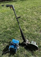 Photo showing the full electric edger and the blue drying blower together on grass.