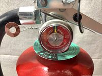 Close-up of pressure gauge showing charge indicator and wiring pin intact.