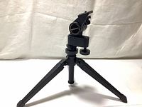 Front view of the Bushnell shooter stand tripod showing the three folded legs and adjustable mount.
