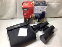 Binoculars with carrying case and retail box, showing included accessories and packaging condition.