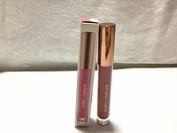Lipgloss and its packaging side by side showing the color and branding.