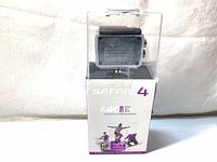 Front view of the Safari 4 action camera in its original packaging showing camera behind clear plastic with branding and technical features.